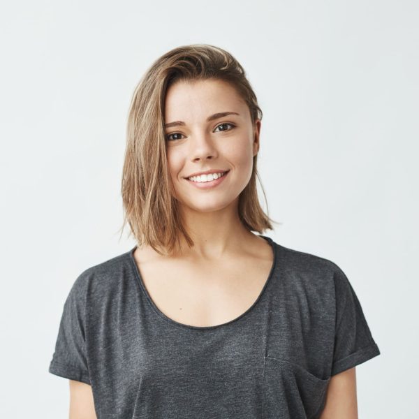 Portrait of young beautiful cute cheerful girl smiling looking at camera over white background. Copy space.